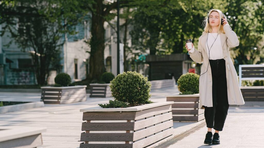 Kobieta pijąca kawę podczas spaceru po letnim mieście.